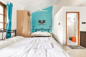 a bedroom with two beds and a blue wall at Casa De Mor Villa with Pool in Anjuna