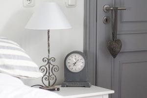 a clock sitting on a table next to a lamp at Ferienwohnung Nina in Egestorf