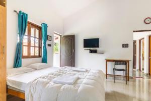 Un dormitorio blanco con una cama y un escritorio. en Casa De Mor Villa with Pool, en Anjuna 30 fotos más
