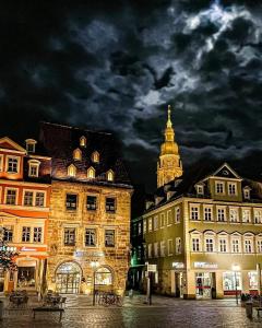 a city with buildings and a clock tower at night at Ferienwohnung Auengrund in Grub am Forst
