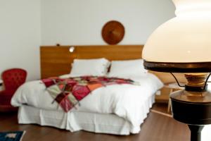 una camera con letto bianco e testiera in legno di Ma Ripoz B&B a Perros-Guirec