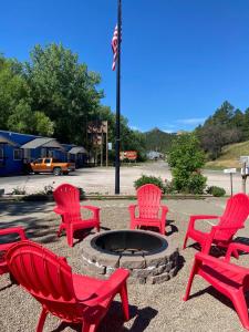 a group of red chairs around a fire pit at The Brookside Motel / Mt. Rushmore in Keystone