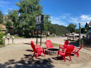 a group of red chairs and a table in front of a motel at The Brookside Motel / Mt. Rushmore in Keystone +37 photos