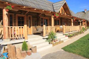 eine Blockhütte mit einer Treppe, die zu einer Veranda führt in der Unterkunft Vila Zlatibor Tornik in Zlatibor