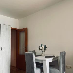 a dining room table with chairs and a vase of flowers at Zora Apartment in Plužine