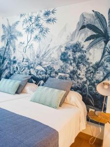 2 camas en una habitación con un mural de plantas en Expoholidays - Plaza Vieja con PARKING gratis, en Almería