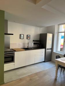 a kitchen with white cabinets and a stainless steel refrigerator at Nouveau Superbe grand T2 centre ville in Pertuis