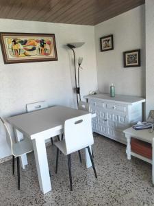 een kamer met een witte tafel en stoelen en een dressoir bij Primera linea de Playa a 1km del puerto de Denia in Denia