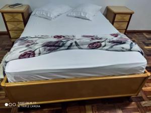 een bed in een kamer met een wit matras bij Flats Paulo & Neia in Foz do Iguaçu
