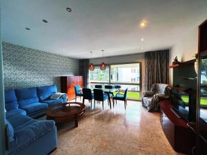 a living room with a blue couch and a table at Cambrils140 in Cambrils