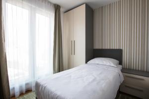 サラエボにあるGreen Nature Hotel & Apartmentsのベッドルーム1室(ベッド1台、大きな窓付)