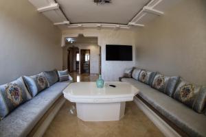 een grote woonkamer met banken en een televisie bij LA PERLE RARE in Agadir