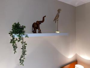 een plank met twee beeldjes en een plant erop bij Robles home in Málaga