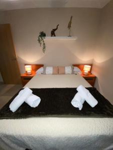 1 dormitorio con 1 cama con toallas y 2 lámparas en Robles home en Málaga