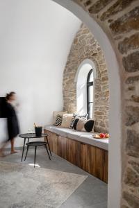 Cette chambre comprend un banc avec des oreillers et une table. dans l'établissement Bridges Residence, à Veliko Tarnovo