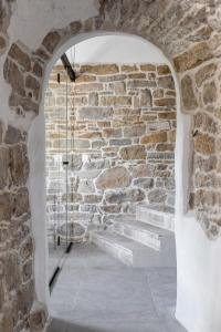einen Torbogen in einer Steinmauer mit einer Treppe in der Unterkunft Bridges Residence in Weliko Tarnowo