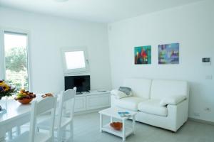 Sala de estar blanca con sofá blanco y mesa en La Casa di Gianluca en Golfo Aranci