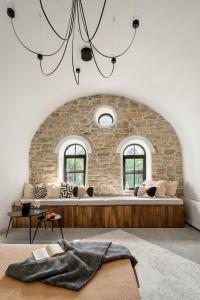 a living room with a large couch in front of a stone wall at Bridges Residence in Veliko Tŭrnovo