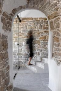 a person walking up the stairs in a brick wall at Bridges Residence in Veliko Tŭrnovo