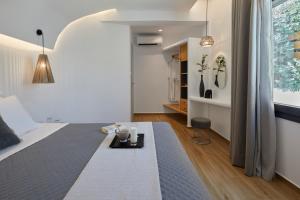 a bedroom with a bed and a table in it at Grand-Mere Calliope in Fira