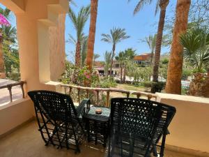 a table and chairs on a balcony with palm trees at BLUE Lagoon View Resort & Spa in Marsa Alam City