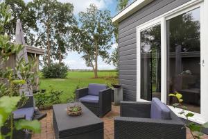 a patio with two chairs and a table at Landelijk chalet 87 in Oosterwolde