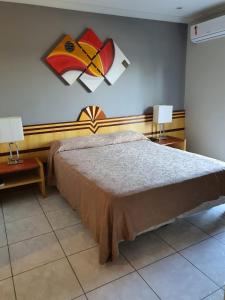 a bedroom with a large bed and two lamps at Hotel Aquarius do Vale in São José dos Campos