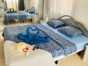 1 dormitorio con 2 camas azules con sombreros y toallas en Preciosas habitaciones en la casa de May en Arona