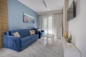 a living room with a blue couch and a table at Maya apartments Hanioti in Hanioti
