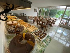 a long table with many different types of pastries on it at Pousada Princesa Isabel - Visconde in Petrópolis
