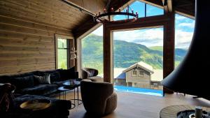 a living room with a couch and a large window at Mlodge - The Mountain Lodge in Sogndal