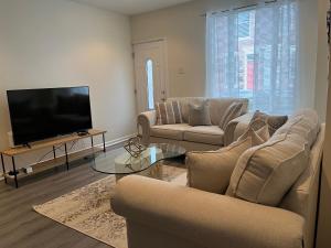 a living room with two couches and a flat screen tv at Cozy Home located in a prime area. in Philadelphia
