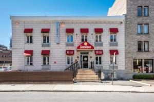 un gran edificio de ladrillo con toldos rojos. en Samesun Montreal Hotel & Hostel, en Montreal