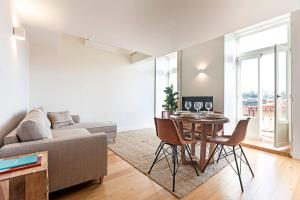uma sala de estar com uma mesa e um sofá em Stunning Duplex Near River by LovelyStay no Porto