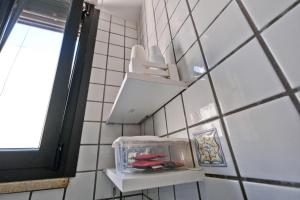 pared de azulejos blancos con estante en el baño en Appartamento Porta Napoli, en Brindisi 20 fotos más