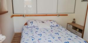 Łóżko w małym pokoju z poduszkami z niebieskiego ptaka w obiekcie House Isabella w mieście Nečujam