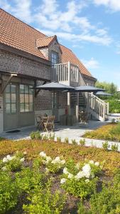 un edificio con un patio con una sombrilla grande en B&B 't Meesterhof, en Deinze