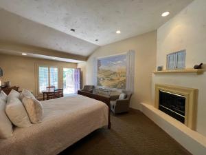 a bedroom with a large bed and a fireplace at Petit Logis Inn in Yountville