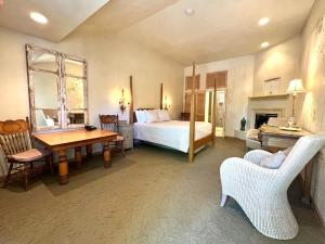 1 dormitorio con 1 cama, mesa y sillas en Petit Logis Inn, en Yountville