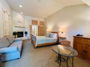 a living room with a bed and a couch and a table at Petit Logis Inn in Yountville