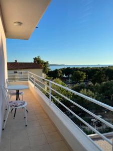 a balcony with a table and a view of the ocean at Apartment Maxim in Primošten