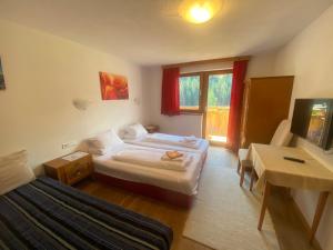 a hotel room with a bed and a television at Alpenrose-Apart in Nauders