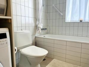 a white bathroom with a toilet and a bath tub at Sunnuhlíð 19 in Akureyri