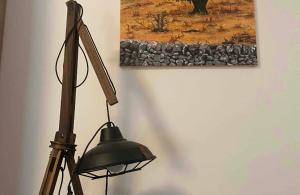 a black lamp sitting next to a wall with a painting at Intown - Dammuso in pieno centro storico in Scicli