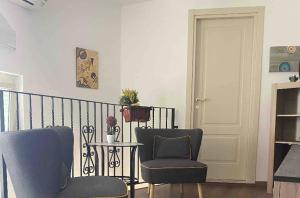 uma sala de estar com duas cadeiras e uma mesa em Intown - Dammuso in pieno centro storico em Scicli