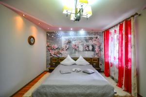 1 dormitorio con 1 cama con una pintura en la pared en Pensiunea Caro, en Deva