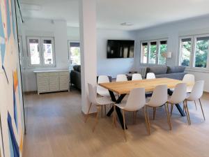 - une salle à manger et un salon avec une table et des chaises dans l'établissement Villa El Encinar de Noja, à Noja