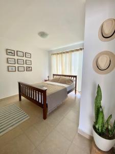 um quarto com uma cama e um vaso de plantas em Moderna casa con piscina a 10 min de la playa em Coclé