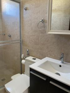 een badkamer met een toilet, een wastafel en een douche bij Moderna casa con piscina a 10 min de la playa in Coclé