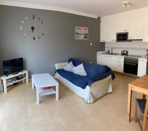 a living room with a couch and a kitchen at Family Heaven - No Stress Holidays in El Cotillo